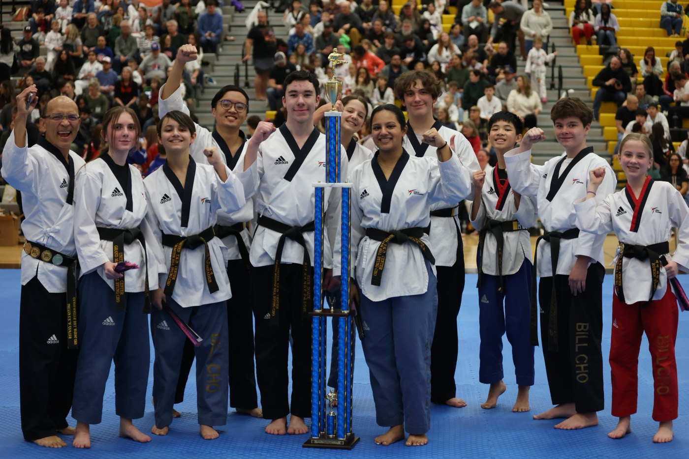 Bill Cho's demo team celebrating with a championship trophy at a tournament