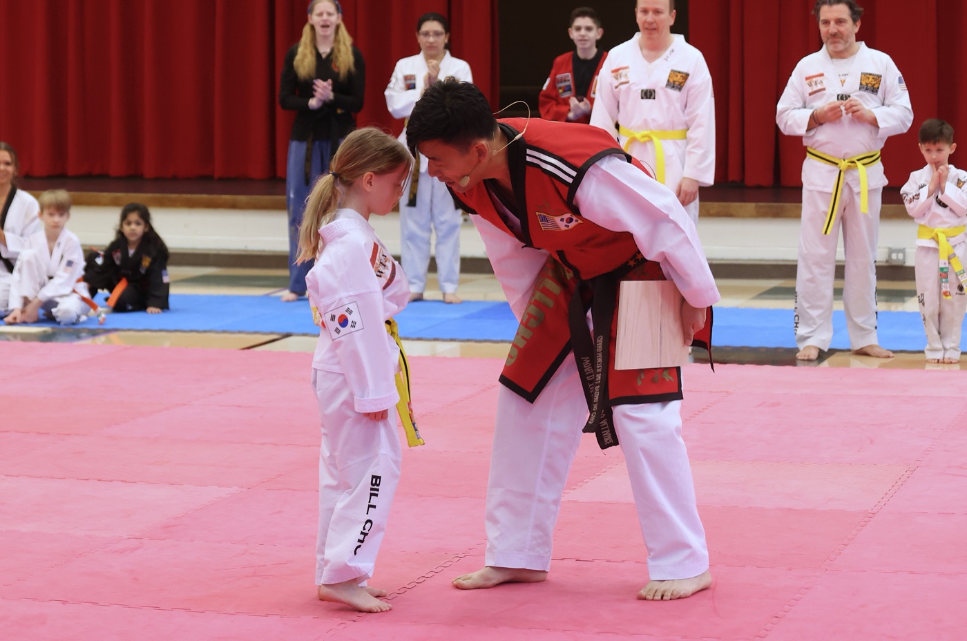 A young Bill Cho's student bowing to her instructor on the competition mat