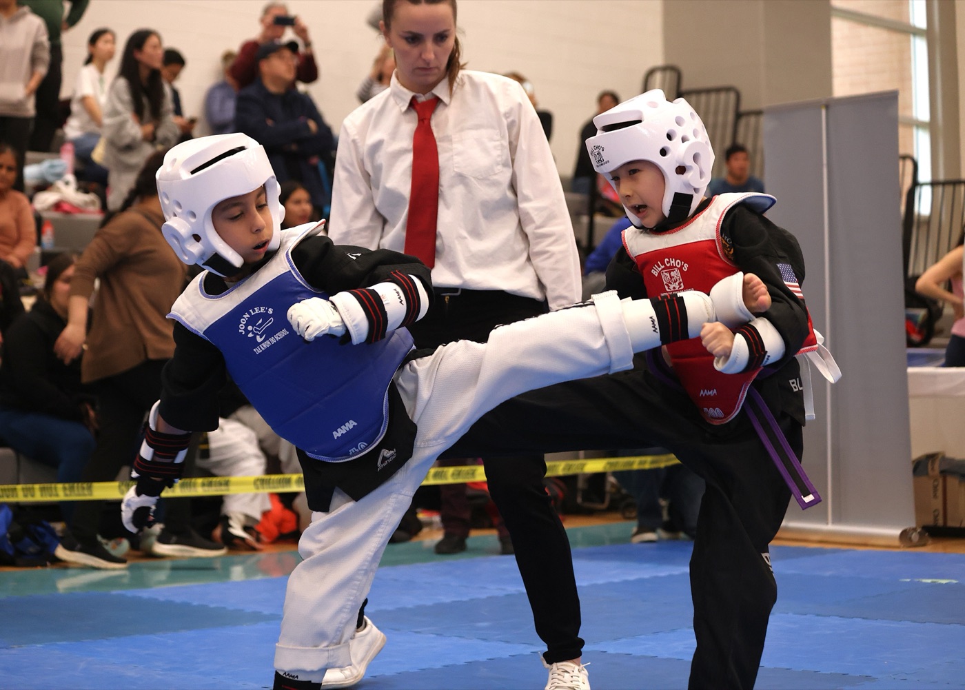 Two Bill Cho's kids sparring in full gear at a regional tournament