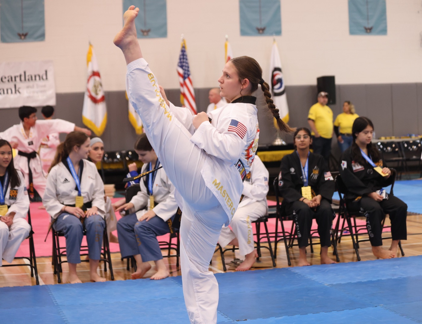 Bill Cho's teen black belt executing a high side kick at a tournament